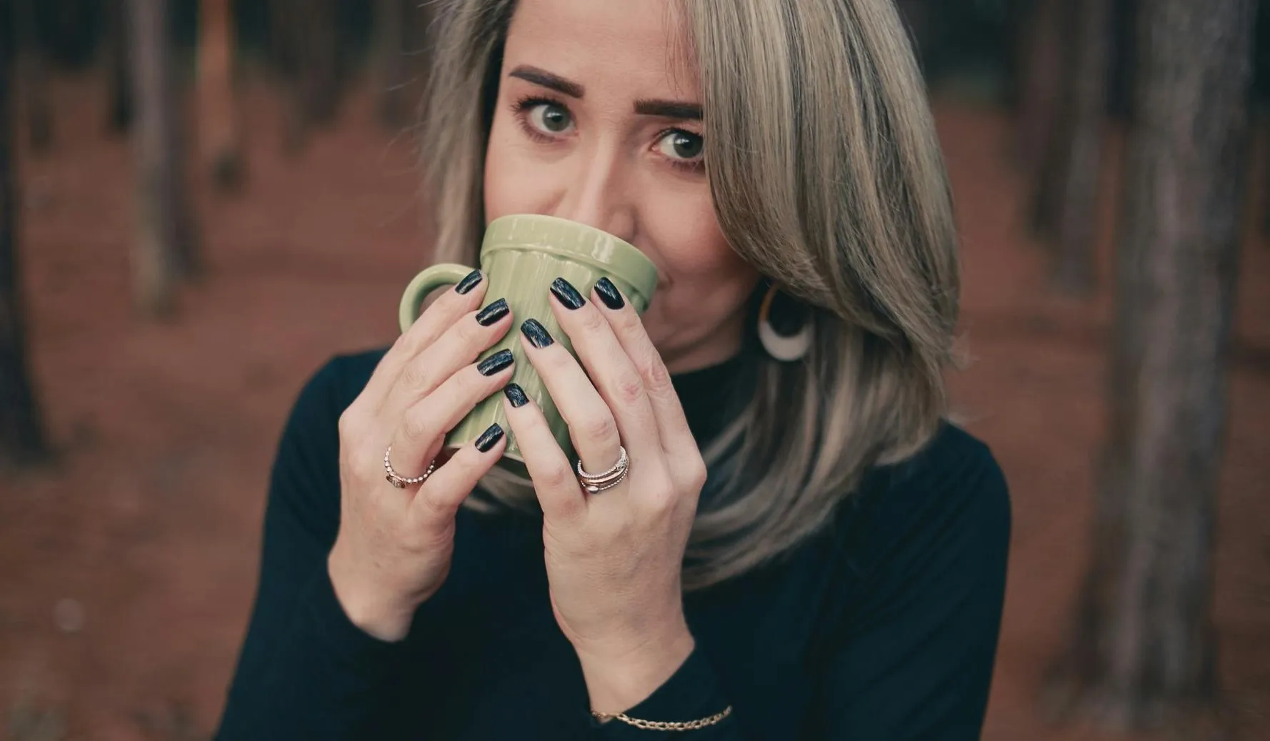 Grauhaarige Frau trinkt Kaffee