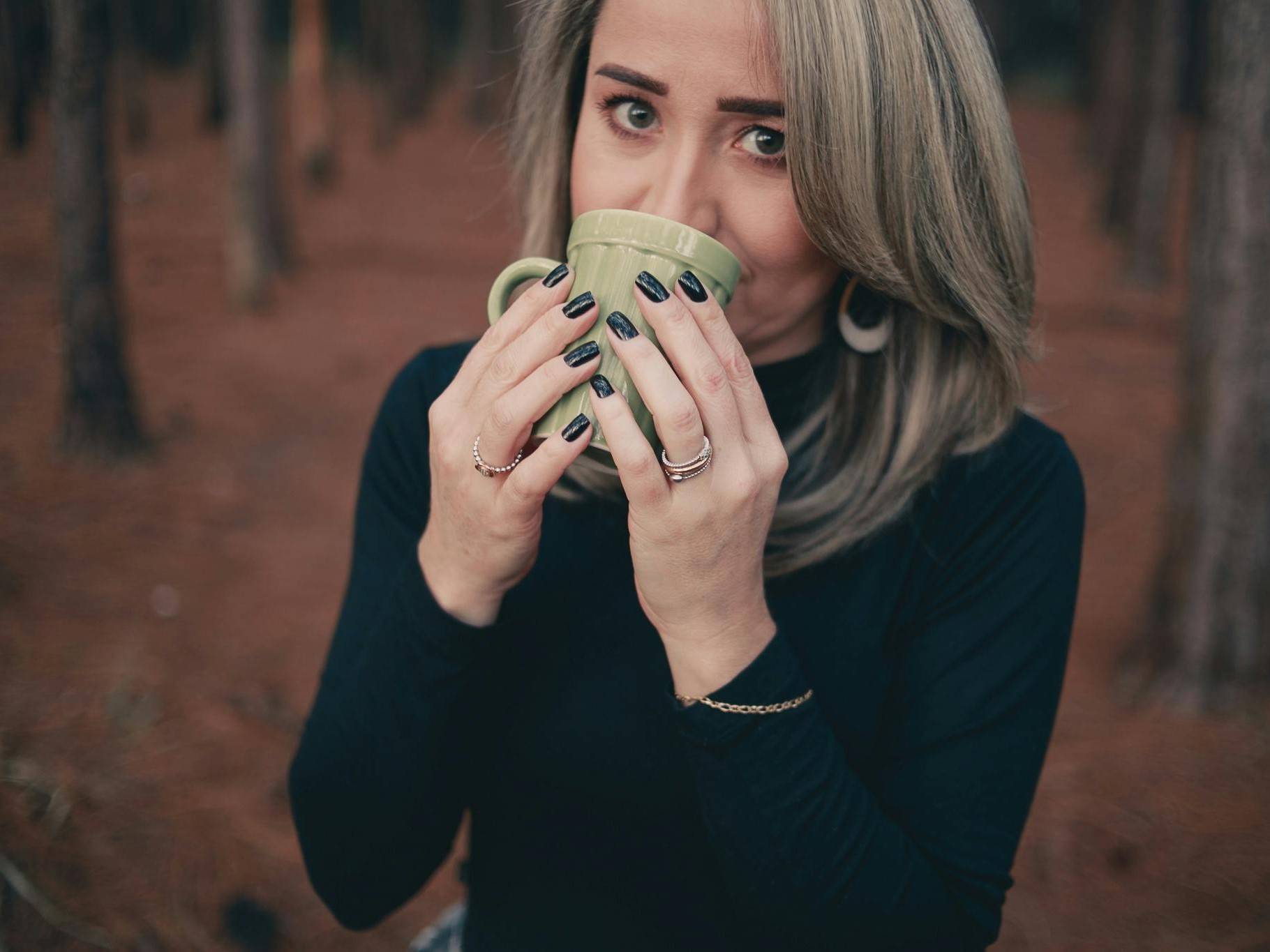 Grauhaarige Frau trinkt Kaffee
