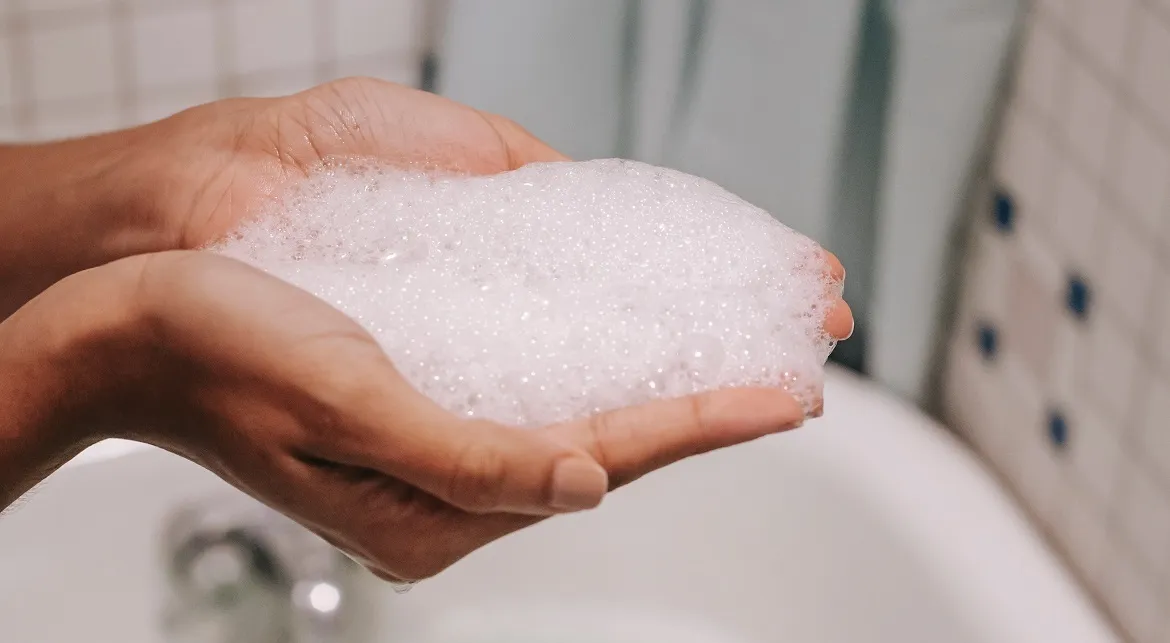 Frau mit Schaum in den Händen