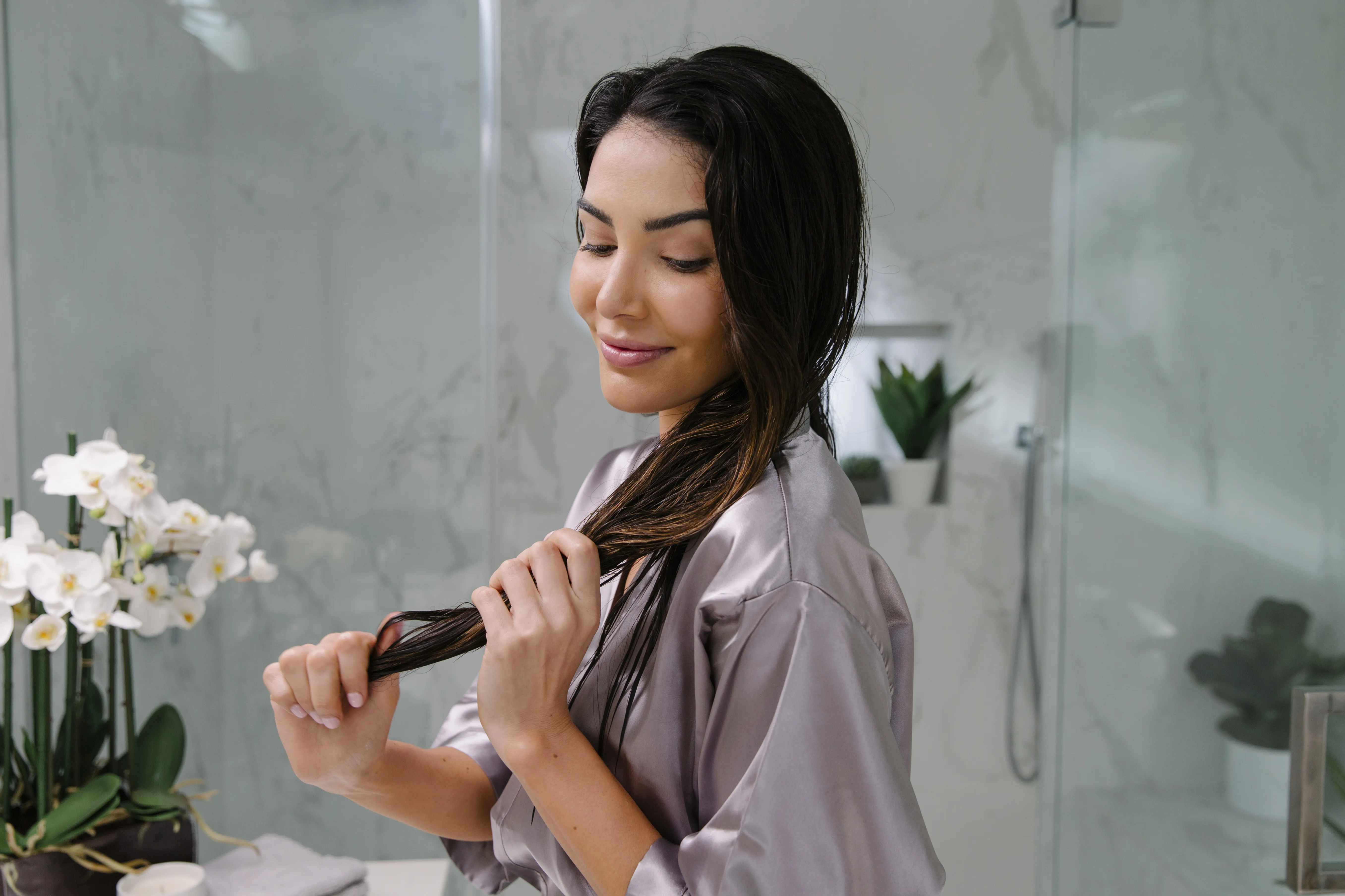 Frau mit langen braunen Haaren im Badezimmer
