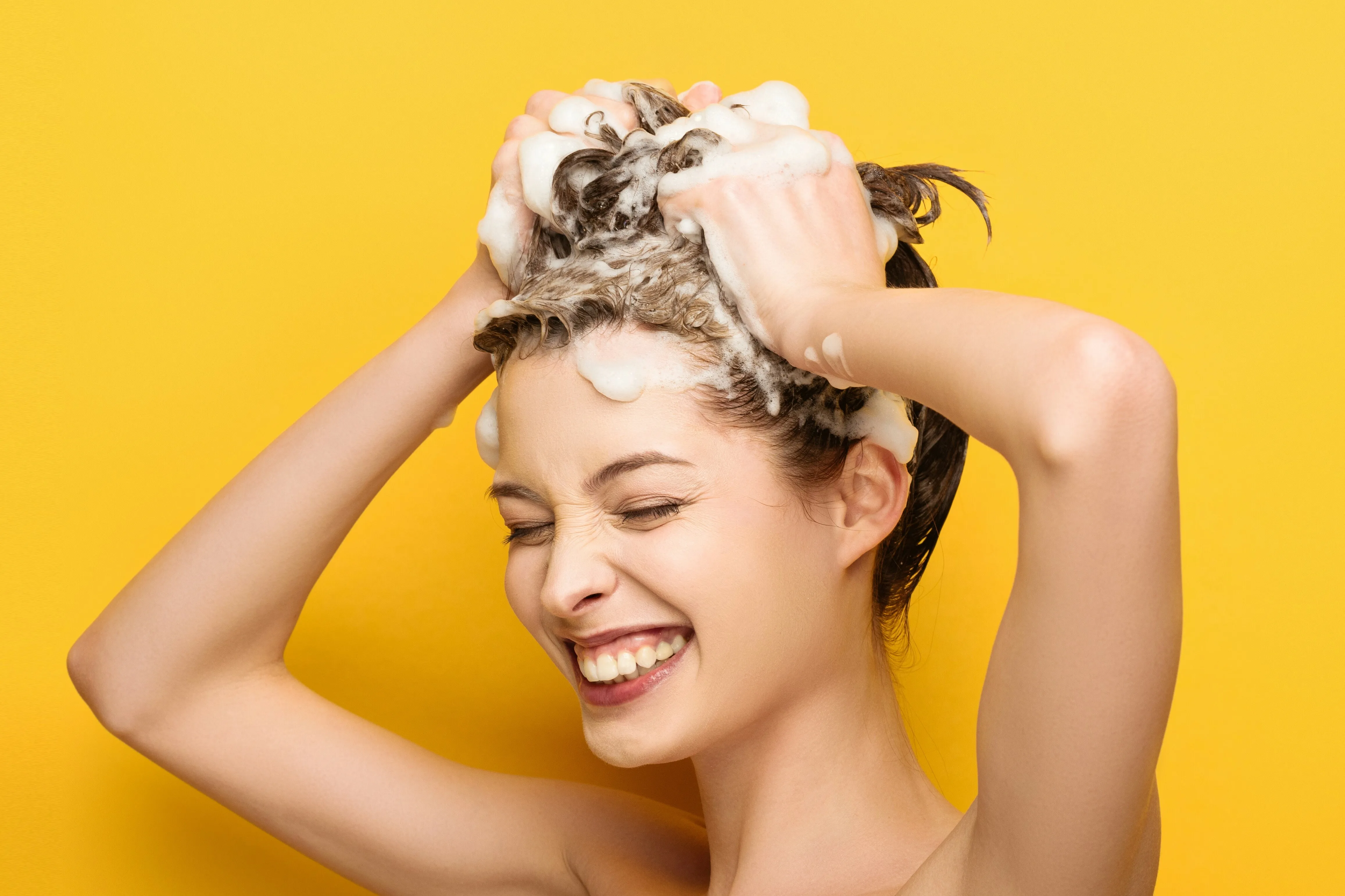 Frau mit Shampoo im Haar