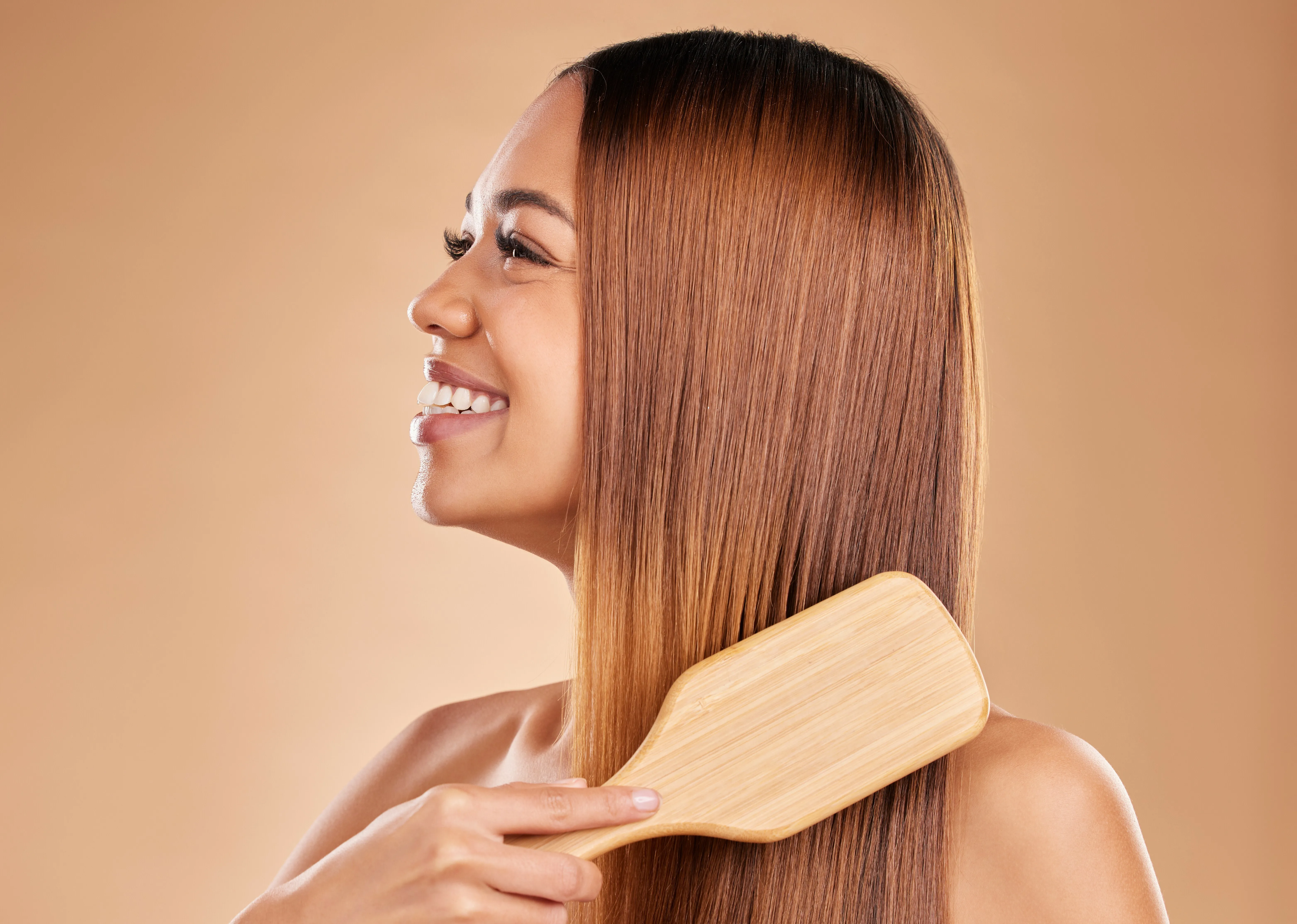 Frau mit glatten Haaren und Bürste in der Hand