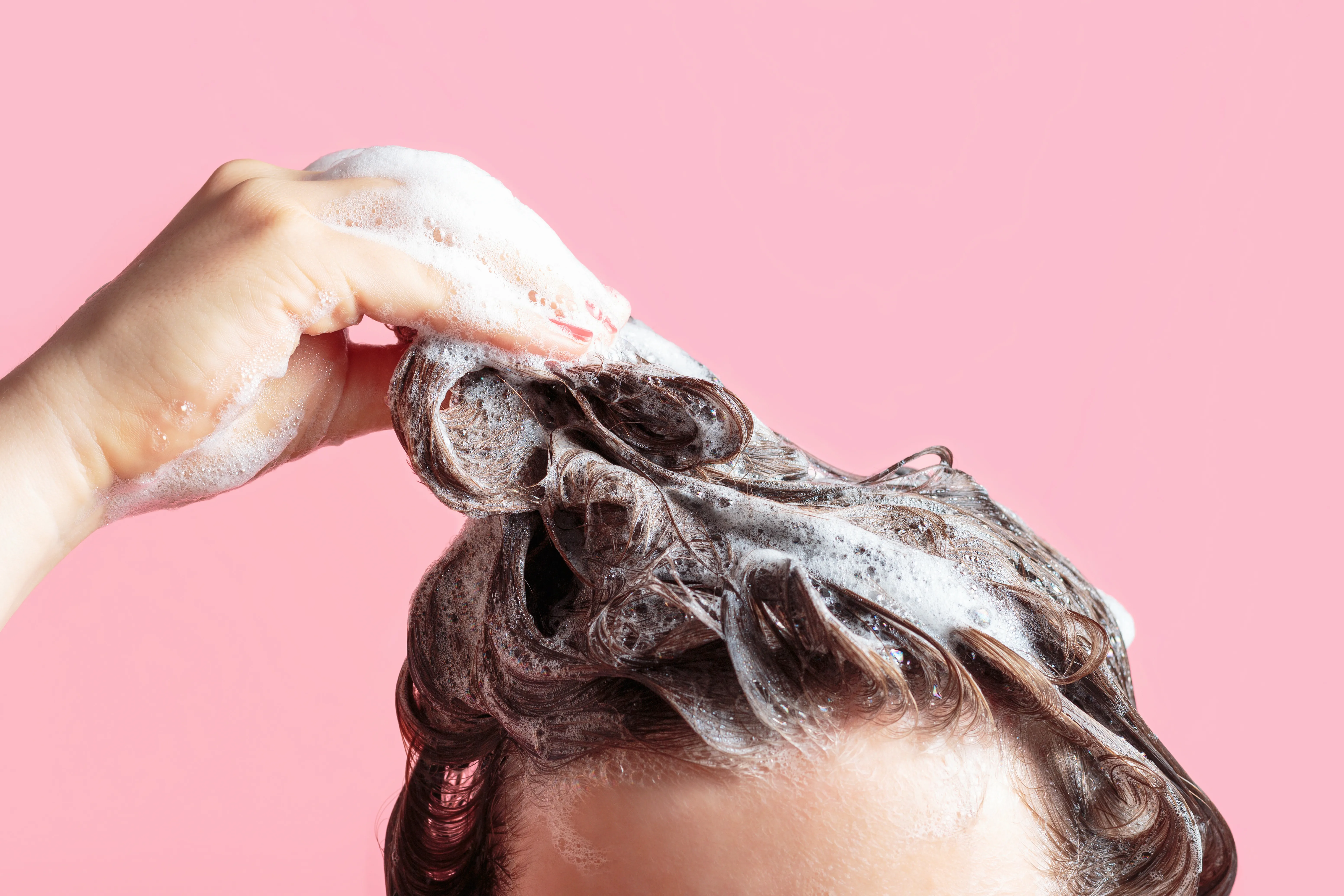 Frau shampooniert ihre Haare