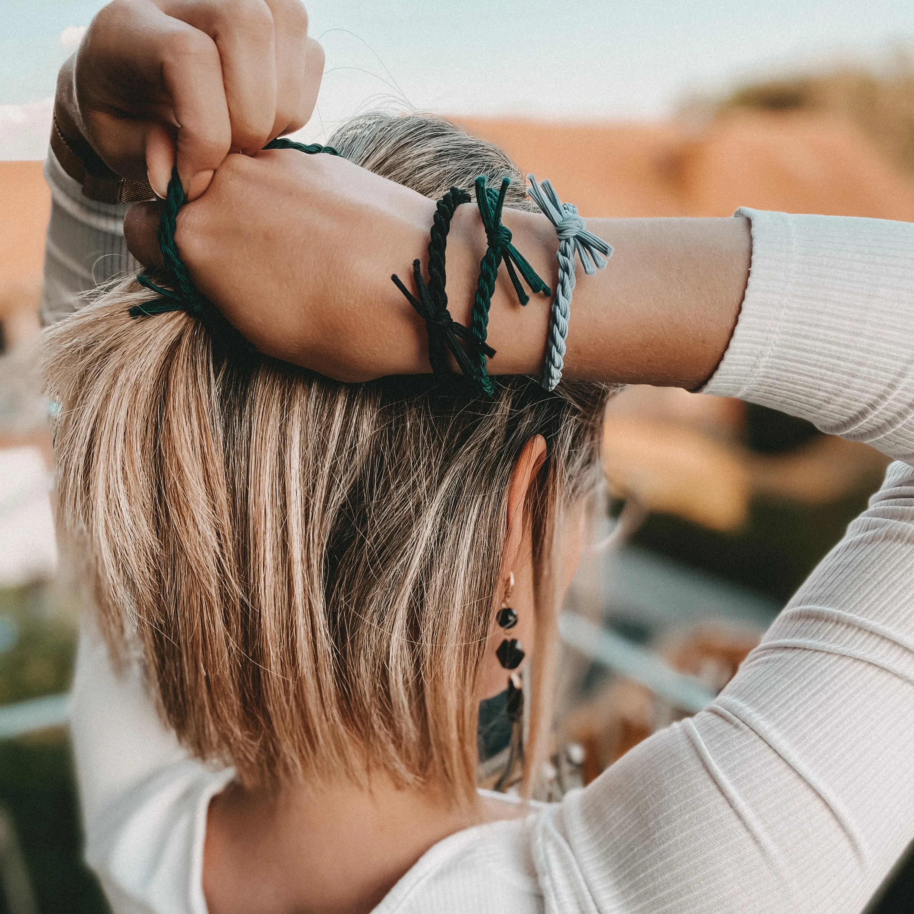 Frau mit Bellody Haargummis im Haar und am Handgelenk